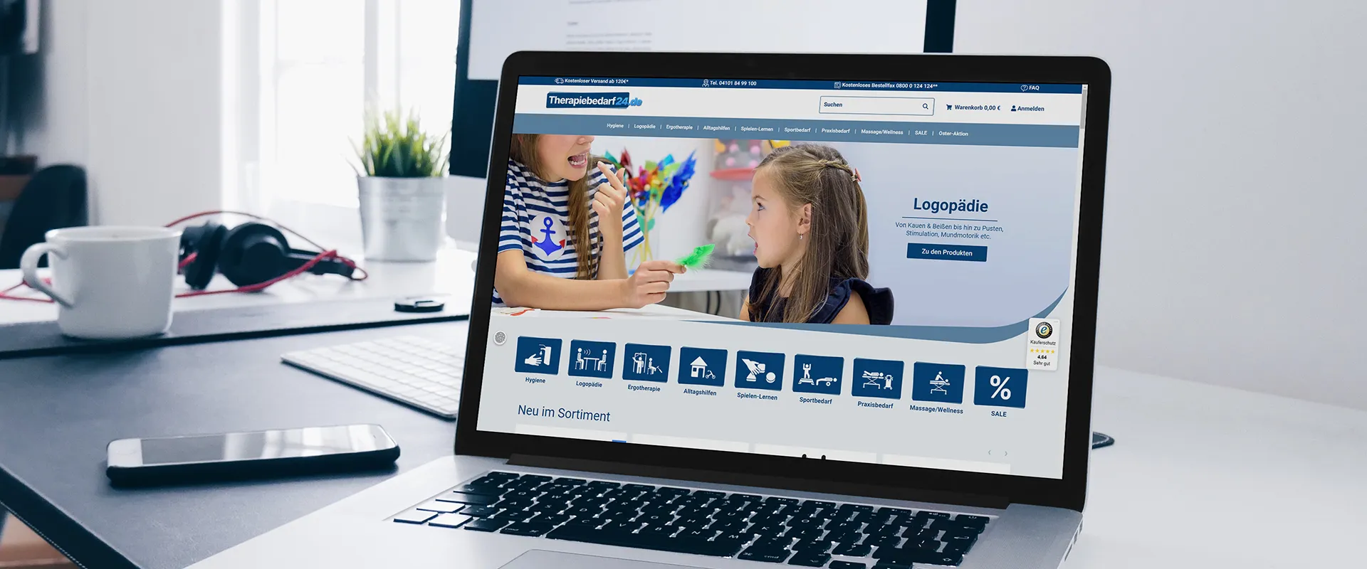 Therapiebedarf24 JTL-Onlineshop für Therapieprodukte und Praxiseinrichtung - Laptop mit der Kategorieseite Logopädie, der auf einem Bürotisch steht
