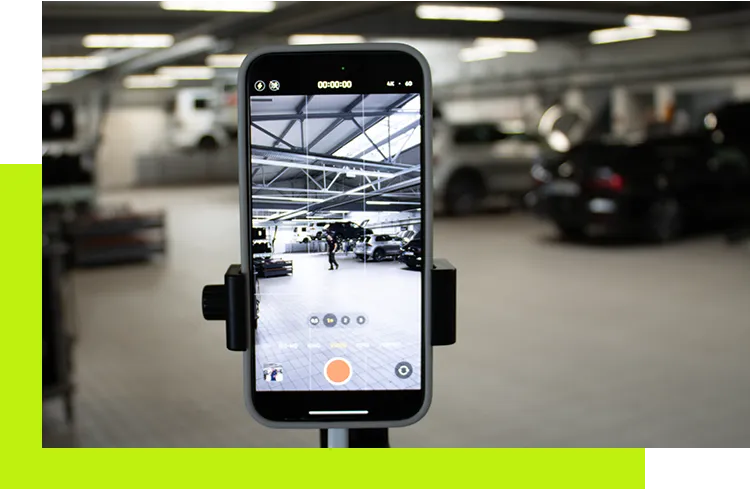 Social Media Konzept - Smartphone auf Stativ filmt in einer Kfz-Werkstatt zur Erstellung von Social-Media-Content für professionelle Unternehmensprofile