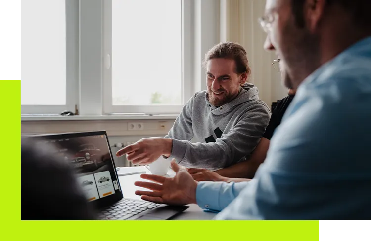 Plugin Programmierung - Entwicklerteam bespricht Plugin-Programmierung an einem Laptop im Büro