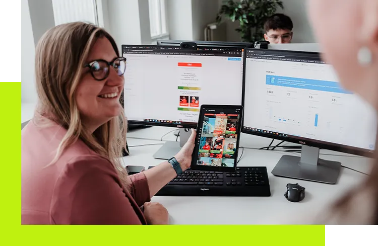 Mitarbeitergewinnung online - Social Media Managerin zeigt Social-Media-Kampagne auf Tablet zur Visualisierung von Employer-Branding-Inhalten
