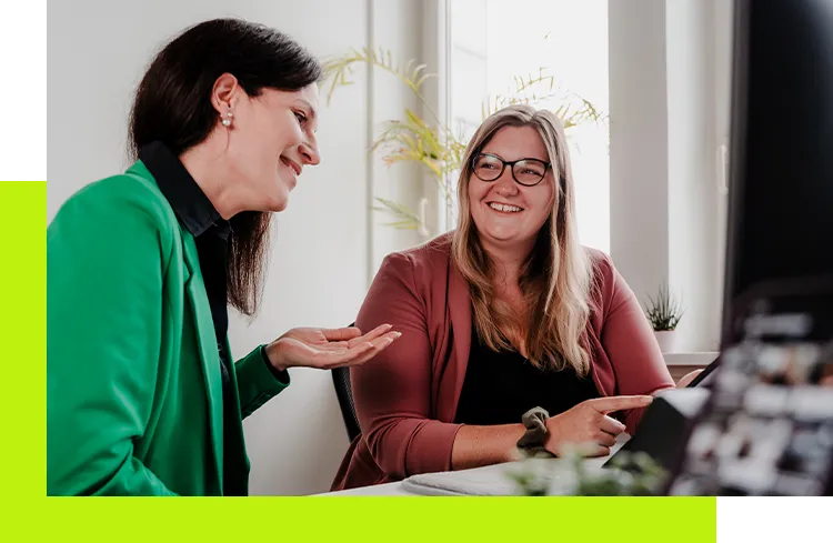 Employer Branding Agentur - Social Media Managerin bespricht mit Kollegin die Umsetzung einer Arbeitgeberkampagne für verschiedene Plattformen