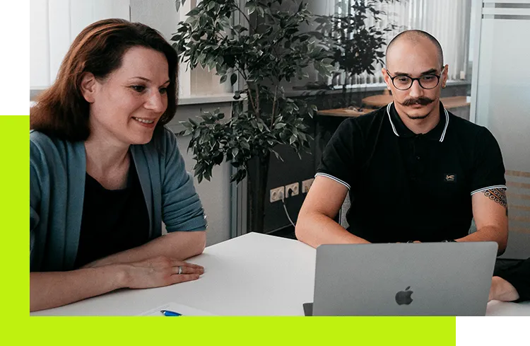 Karriere Online-Marketing-Manager - Mitarbeiter von imc sehen sich einen Bildschirm an